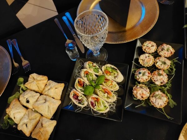 Catering z widocznymi przekąskami na elegancko zastawionym stole.