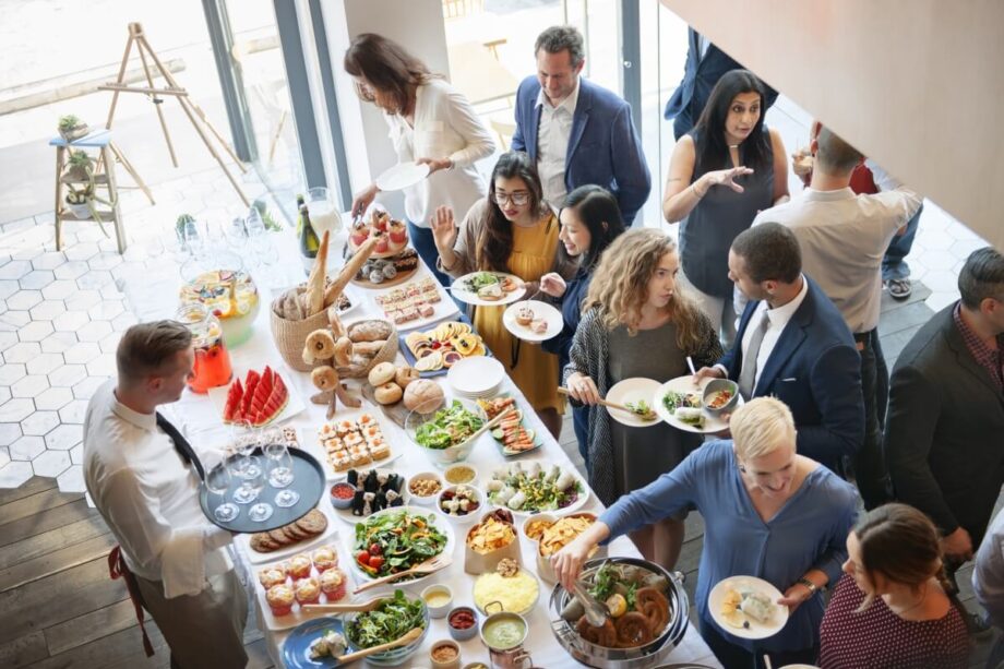 Grupa ludzi cieszy się bufetem przygotowanym jako catering na eventy.