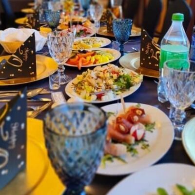 Stół zastawiony jedzeniem na przyjęcie, przygotowany przez catering.